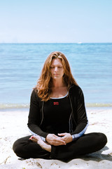 Fototapeta na wymiar A woman in deep meditation at the beach