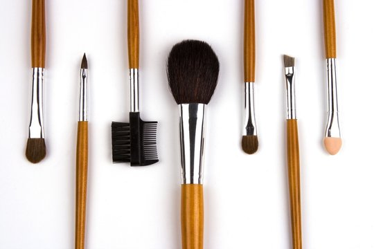 Cosmetic Brushes Lined Up In White Background.