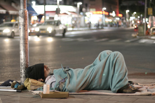 male homeless sleeping in a street