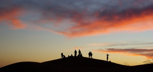 Silhouettes sur la dune au coucher du soleil