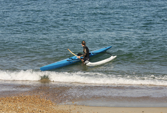 homme qui arrive avec une pirogue sur la plage