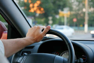 The man holds a rudder of the car