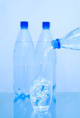 Bottles of mineral water with a glass. Isolated