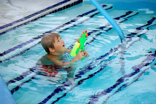 Little Boy Squirting Watergun In The Air