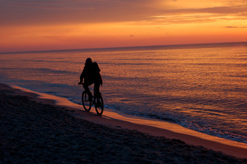 man riding bike at sunset