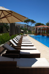 line of chaise longues by the pool