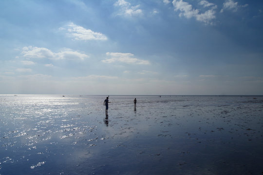 People On A Beach In Low Tide (Norfolk, UK)