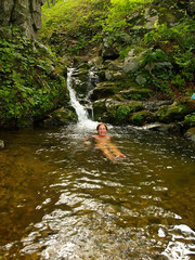 happy girl bathing in the forest waterfall