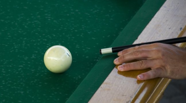 billiard cue beating on a ball