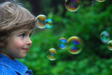 beautiful four years old playing with bubbles