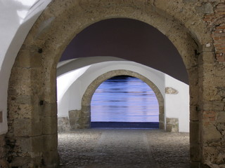 Obraz premium blick durch mittelalterlichen torbogen auf inn fluss