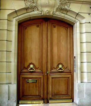 Porte vernie marron avec poign&eacute;es dor&eacute;es.