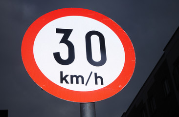 An Irish 30 kmh speed sign in the dark night sky.