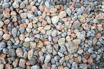 Natural pastel colors beach stones covered in raindrops.