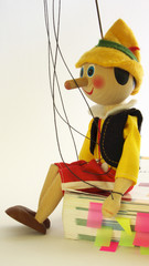 Wooden puppet sitting on the book