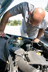 Businessman opening the trunk and checking the engine of a car