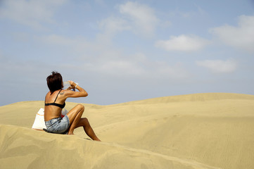 Fototapeta na wymiar Kobieta picia na pustyni