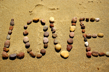 Love stone word in the sand