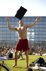 man balancing backgammon/suitecase on head in the sun 