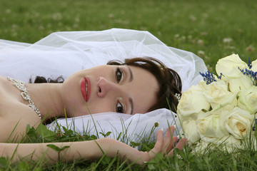 beautiful bride laying on the grass