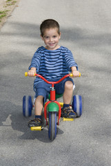 lachendes Kind am Dreirad