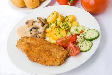 Paniertes Schnitzel mit Bratkartoffeln,Tomaten-Salat