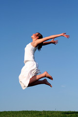 Woman jumping against blue sky