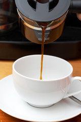 Coffee being poured into white cup