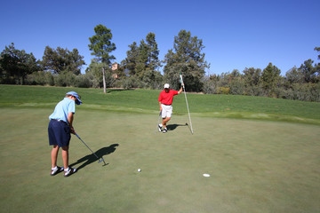 Father and son golfing on green