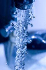water  running down from faucet in blue color
