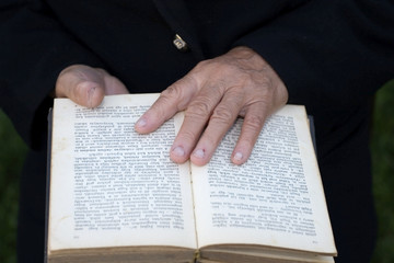 Naklejka premium Senior's hands on old Bible
