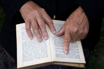 Naklejka premium Senior's hands on old Bible