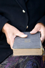 Fototapeta na wymiar Senior's hands on old Bible