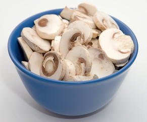 close up sliced mushrroms in blue bowl