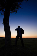 Obraz premium A man's silhouette in the sunset with a tree