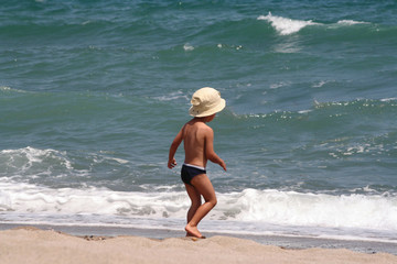 un petit garçon joue avec les vagues