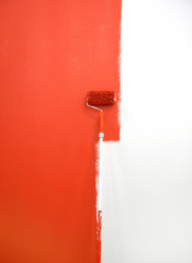 red paint roller by wall