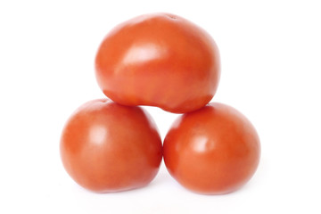 three red tomatoes in a form of pyramid