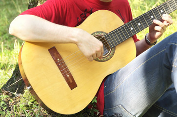 teenage boy playing the acoustic guitar