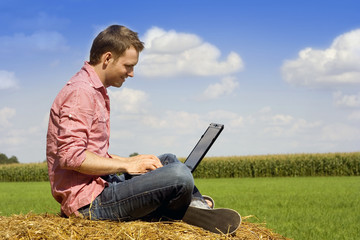 handosme man with laptop over country view.