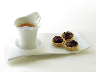 cup of golden tea and cakes for tea-time