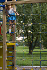 Little girl on playground climbed high