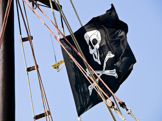 Pirate flag on the sailboat waving in the wind