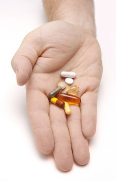 Hand outstretched with a pile of pills