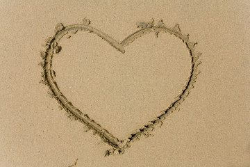 drawing heart on sea sand