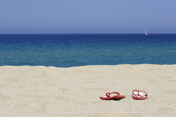 flip flops on empty sandy beach