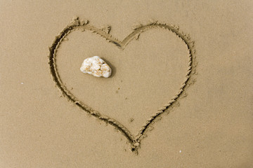 drawing heart on sea sand