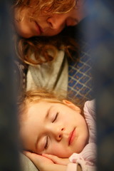 woman and girl sleeping in the airplane