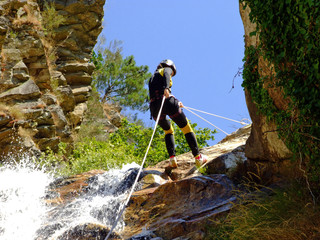 Woman descending on rappel - obrazy, fototapety, plakaty