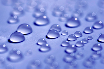 Water drops on blue background close-up